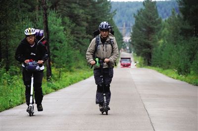 窦一欣（右）和陈萌行进在北极村通往漠河县城的公路上